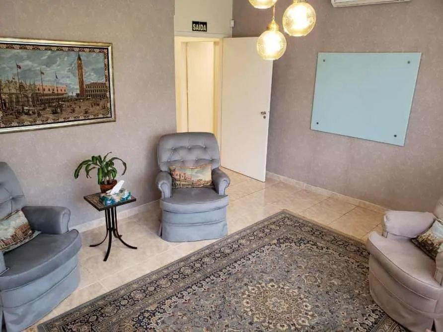 Sala de espera da clínica com poltronas azul-acinzentadas